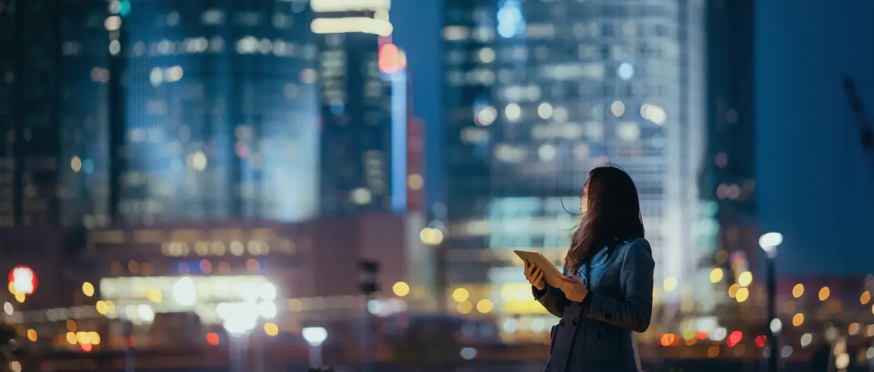 junge Frau mit Tablet vor Skyline