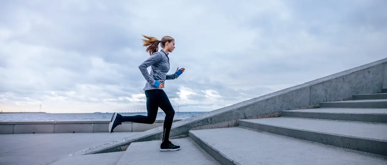 A female jogger running up the stairs.