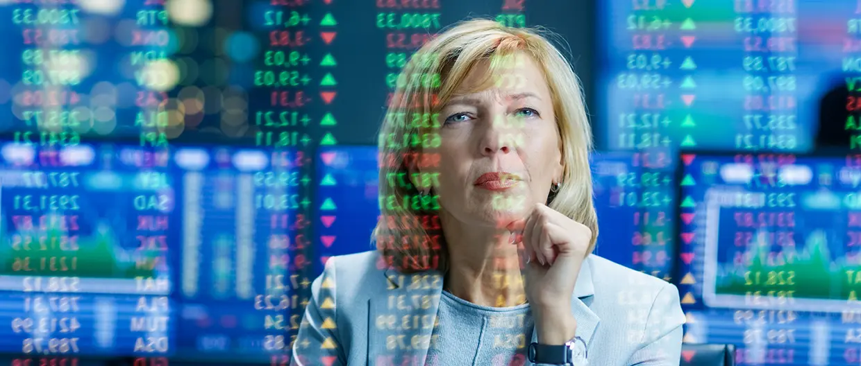 A woman looking at a screen with financial data