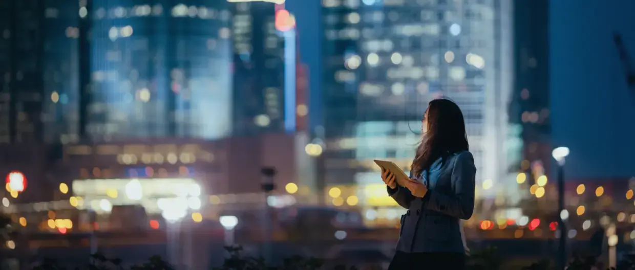 Young women holding Tablet looking at Skyline
