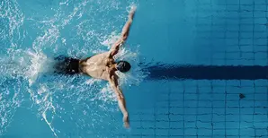 A male swimmer in a swimming pool corridor