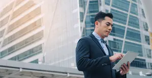 businessman looking a his tablet in the street