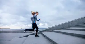 A female jogger running up the stairs.