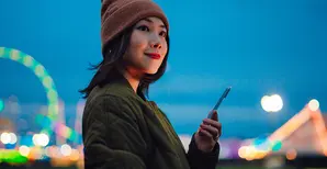 A young Asian woman holding a smartphone