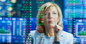 A woman looking at a screen with financial data