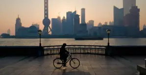 visual of person cycling along pier at dusk