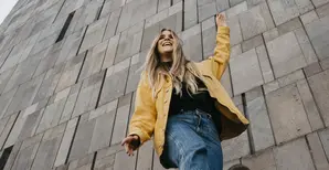 Woman in yellow jacket in front of wall
