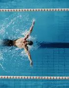 A male swimmer in a swimming pool corridor