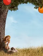 Woman under a tree, eating an apple