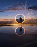 A long-exposure photograph capturing light trails from burning steel wool being spun