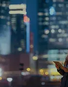 immagine di una ragazza con un tablet in mano su sfondo skyline notturno