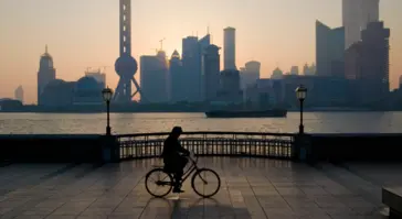 visual of person cycling along pier at dusk
