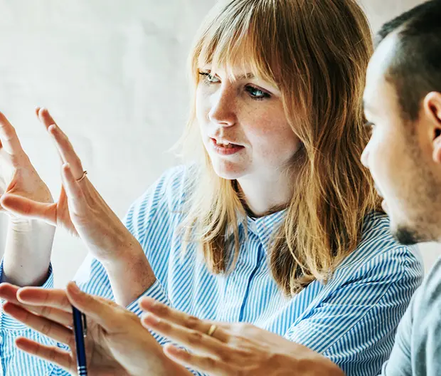 Woman demonstrating for someone at monitor