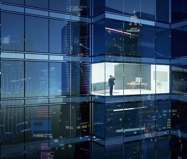 Businessman at a skyscraper building at night