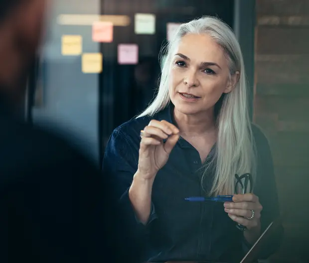 A middle-aged business woman in conversation with a colleague