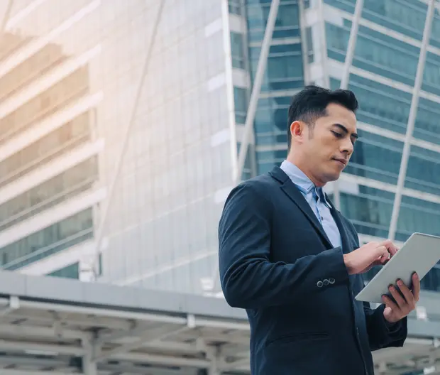 businessman looking a his tablet in the street