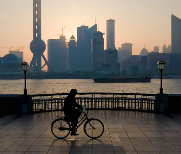 visual of person cycling along pier at dusk