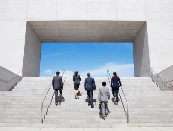 Business people climbing stairs to a tunnel