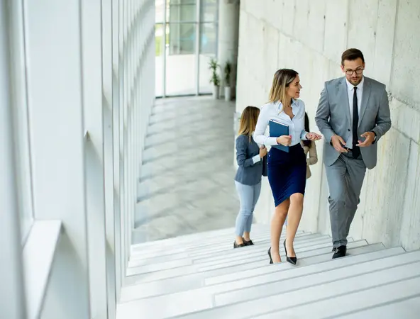 office workers talking while climbing the stairs