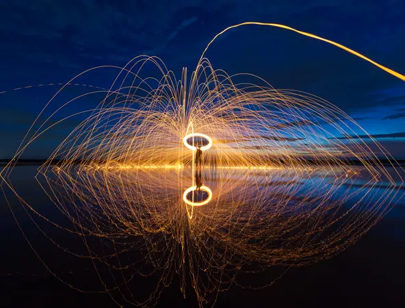 A long-exposure photograph capturing light trails from burning steel wool being spun