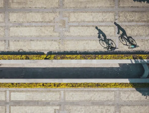 shadow of two cyclists cycling along road in daylight