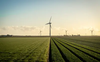 Champs de verdure avec des éoliennes, illustrant des investissements en énergie renouvelable.