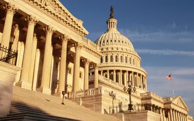 Immeuble du Capitole sous un ciel clair, symbolisant la politique américaine.