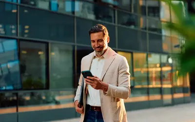 Un salarié consulte son téléphone en sortant du bureau.