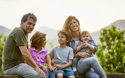 Une famille posant ensemble à l'extérieur, sans lien avec la gestion d'actifs.