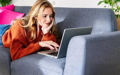 Femme asset manager travaillant sur un ordinateur portable dans un salon moderne.