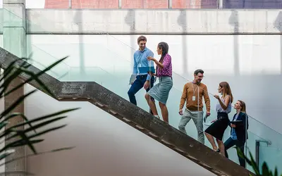 Groupe de personnes descendant un escalier dans les bureaux d'Amundi, ambiance dynamique.