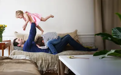 Environnement domestique chaleureux avec un père jouant joyeusement avec sa fille.