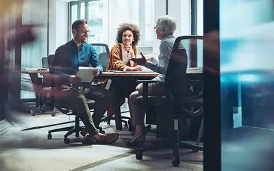 Trois experts en gestion d'actifs discutent dans les bureaux d'Amundi.
