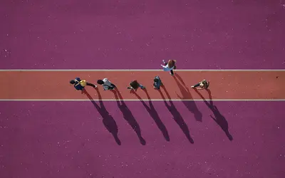 Illustration de silhouettes d'experts financiers marchant sur une piste rose.