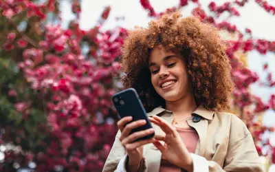 Femme avec un téléphone dans un cadre floral.