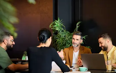 Groupe de quatre salariés en réunion de travail.