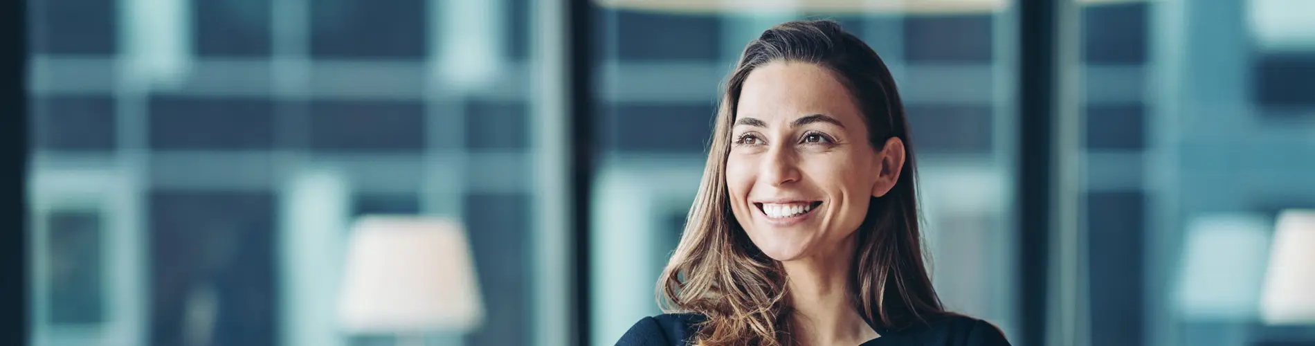 Femme asset manager réfléchissant dans les bureaux d'Amundi, avec de grandes fenêtres en arrière-plan.