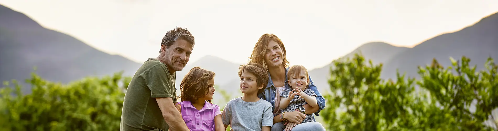 Une famille posant ensemble à l'extérieur, sans lien avec la gestion d'actifs.