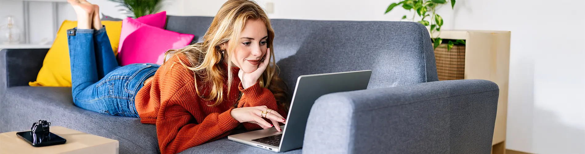 Femme asset manager travaillant sur un ordinateur portable dans un salon moderne.