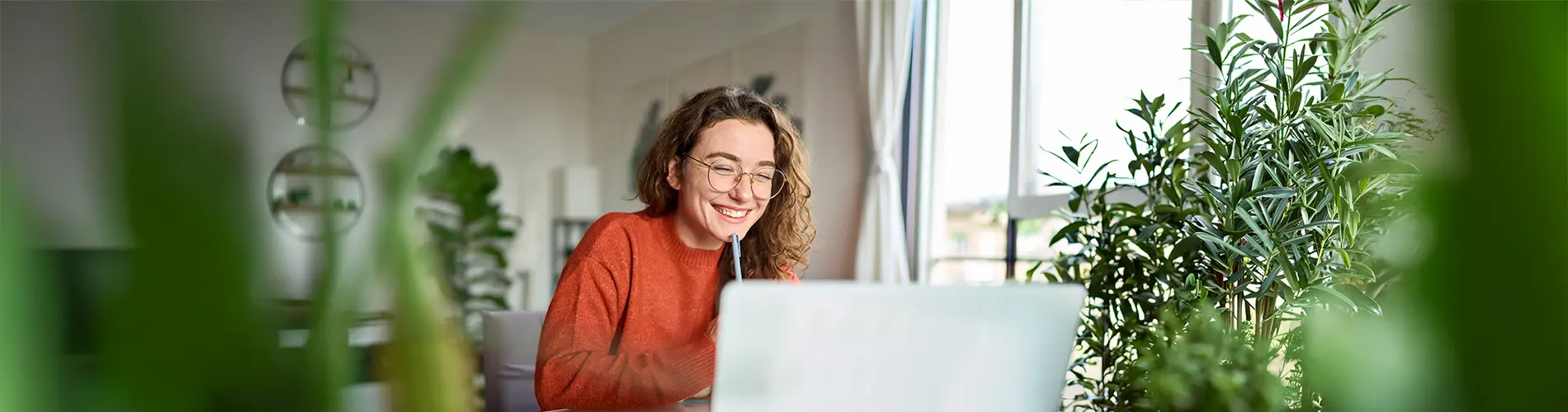 Une experte en gestion d'actifs souriante travaille sur son ordinateur dans les bureaux d'Amundi.