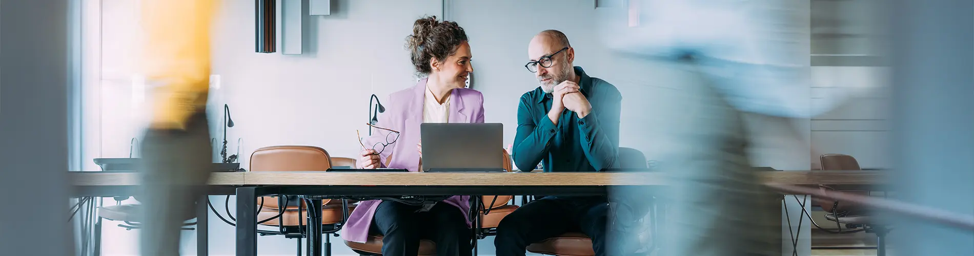 Deux experts financiers discutent devant un ordinateur dans les bureaux d'Amundi.