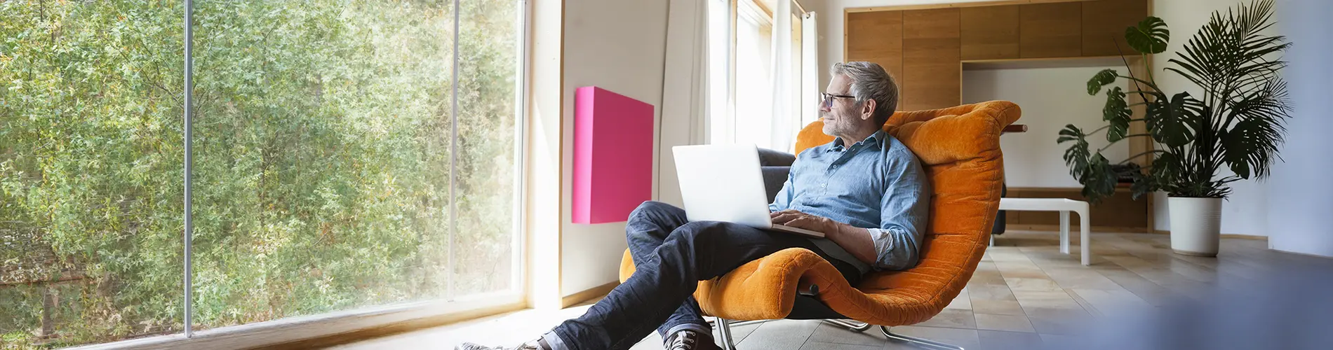 Expert en gestion d'actifs dans un fauteuil, travaillant sur un ordinateur dans un bureau lumineux.