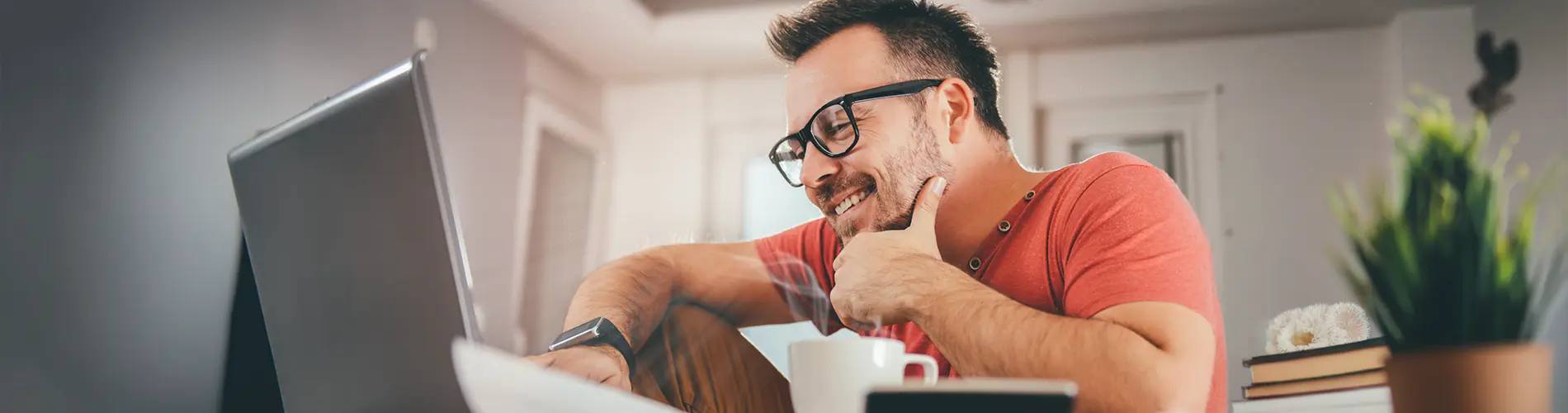 Un gestionnaire d'actifs souriant travaillant sur un ordinateur dans un bureau moderne.