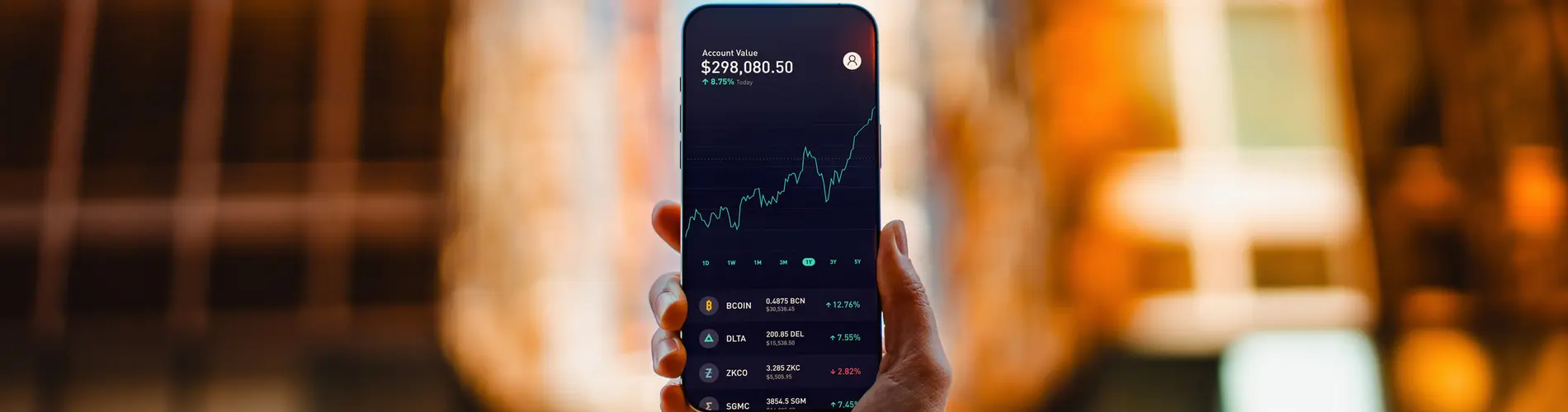 Un expert en finance tient un smartphone affichant une courbe de croissance financière.