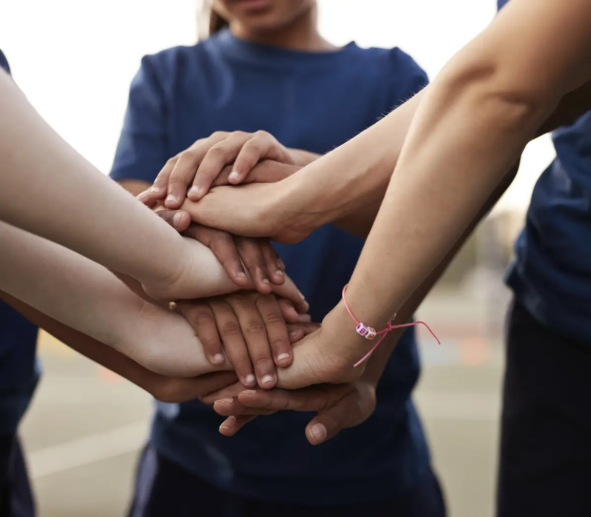 Mains se rejoignant en signe d'unité et de collaboration, évoquant le travail d'équipe.