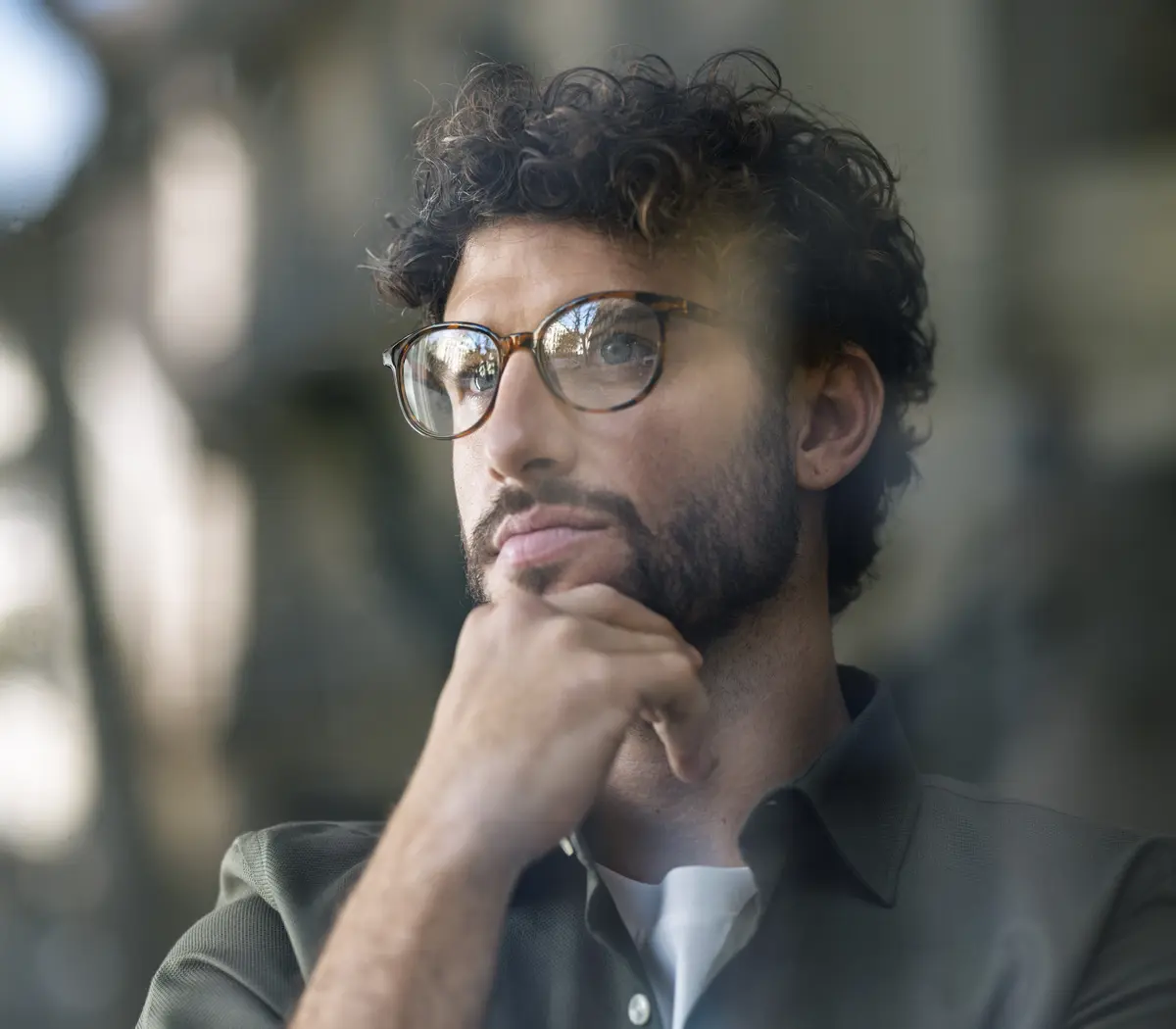 Un homme regarde par la fenêtre et réfléchit.