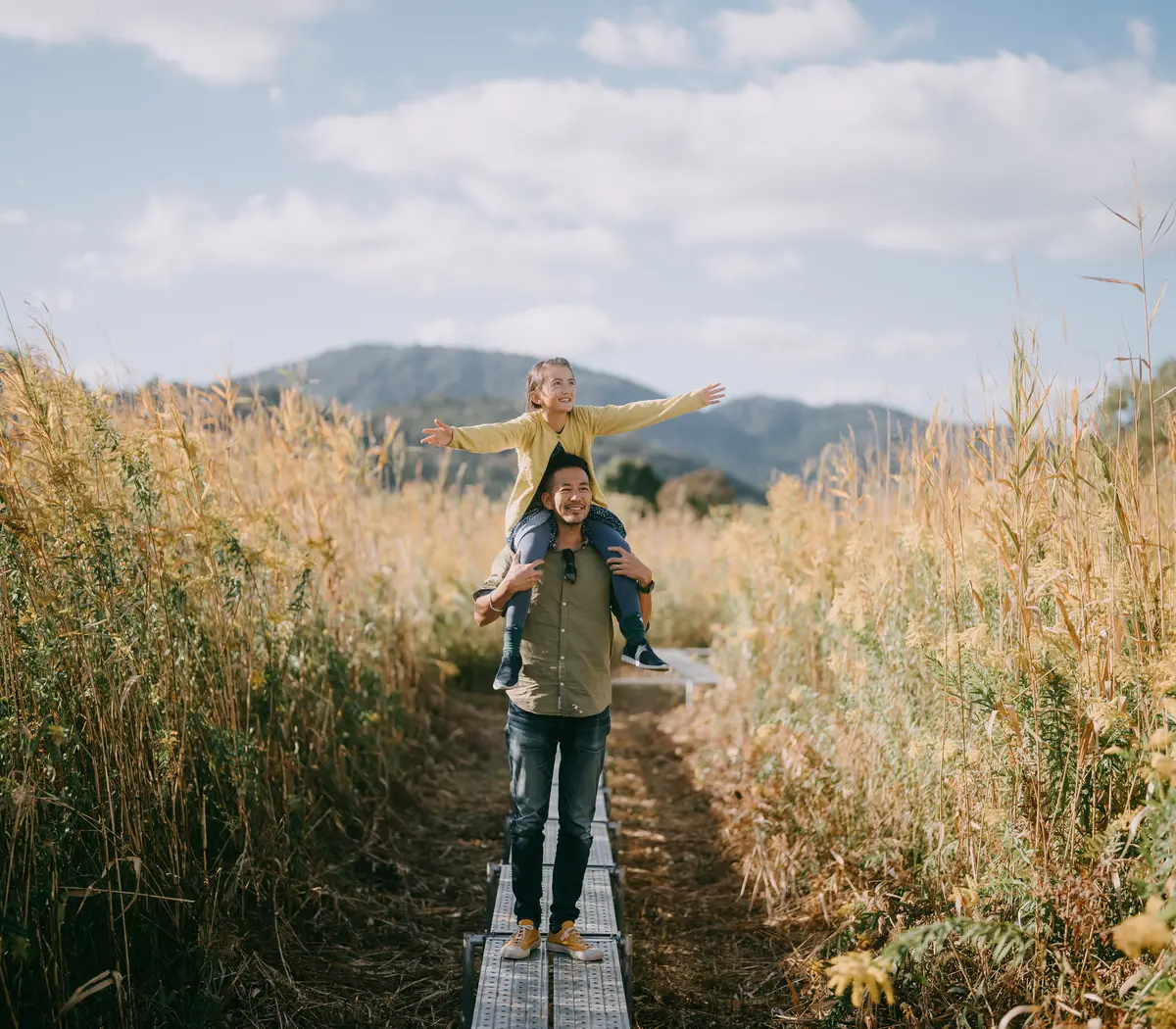 Un père et sa fille heureux se promènent dans la nature à l'automne.
