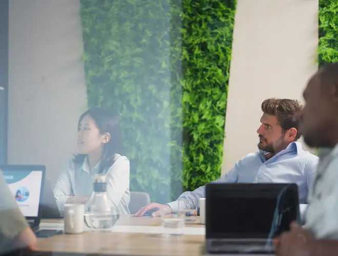 Réunion d'experts en gestion d'actifs dans les bureaux d'Amundi, attentive et collaborative.