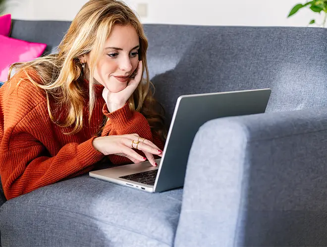 Femme asset manager travaillant sur un ordinateur portable dans un salon moderne.