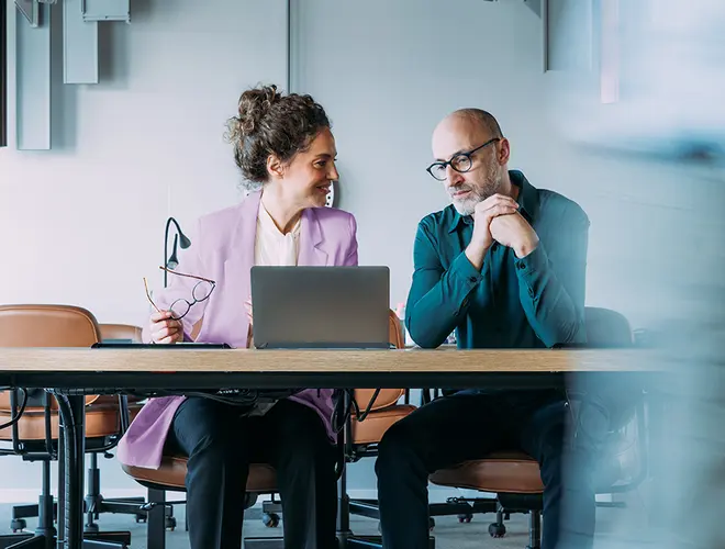 Deux experts financiers discutent devant un ordinateur dans les bureaux d'Amundi.